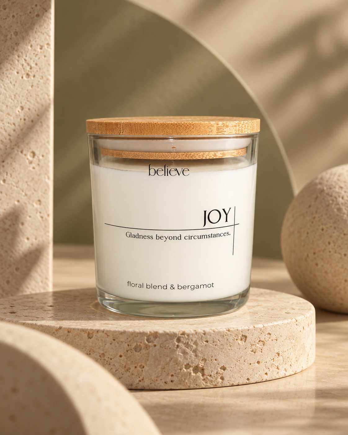 JOY candle with wooden lid on a pale stone plinth