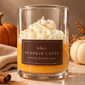 Pumpkin Latte candle styled with pumpkins, dried botanicals and cinnamon sticks on a warm stone surface