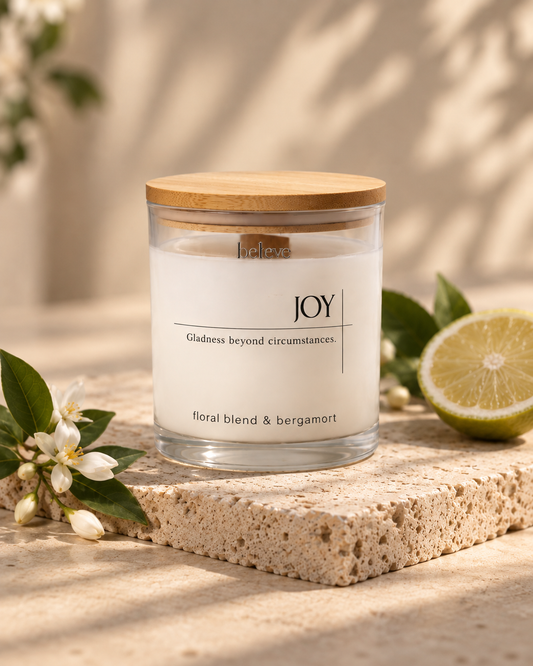 JOY candle with wooden lid, styled with fresh citrus and white blossom