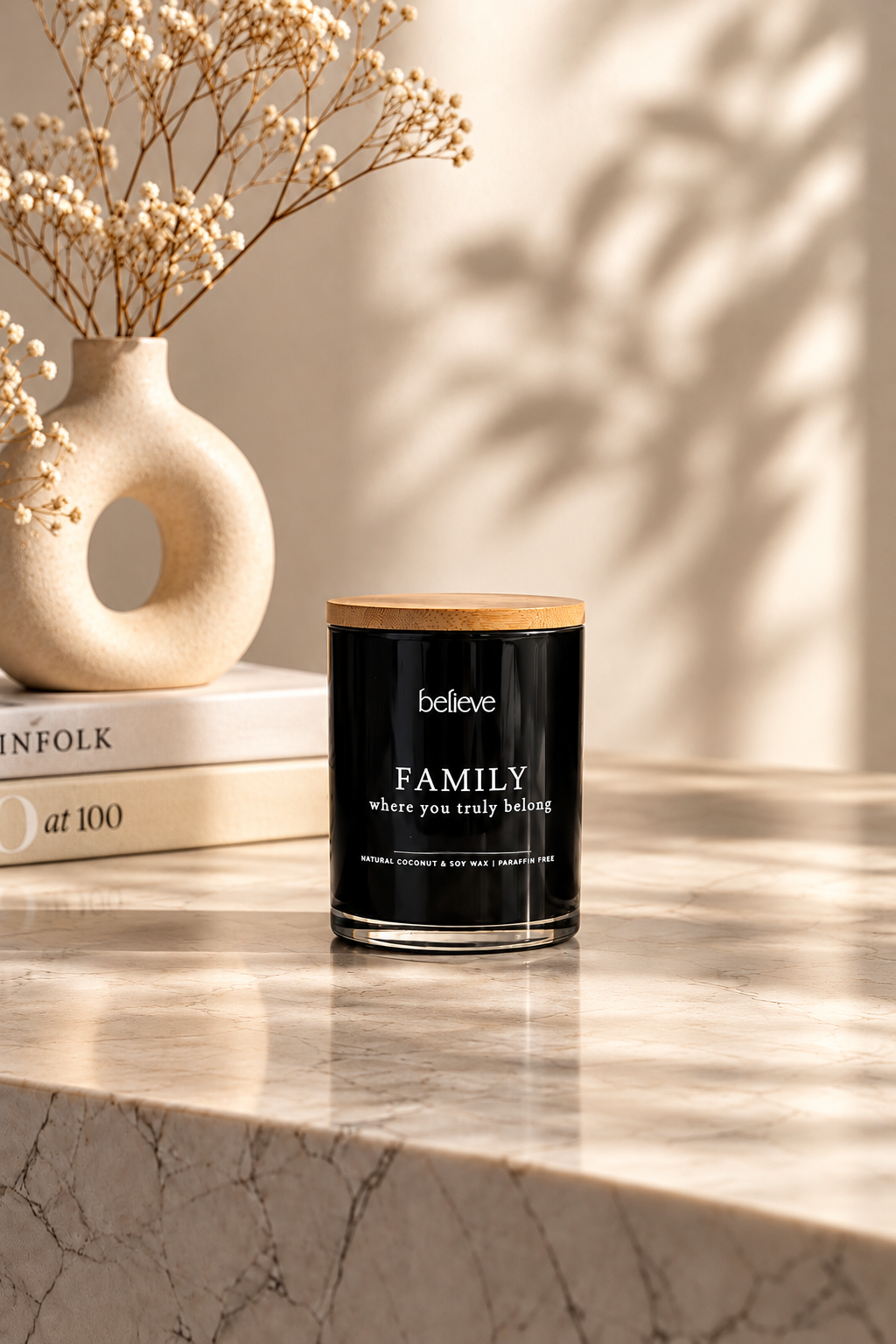 FAMILY candle with wooden lid on a sunlit marble ledge